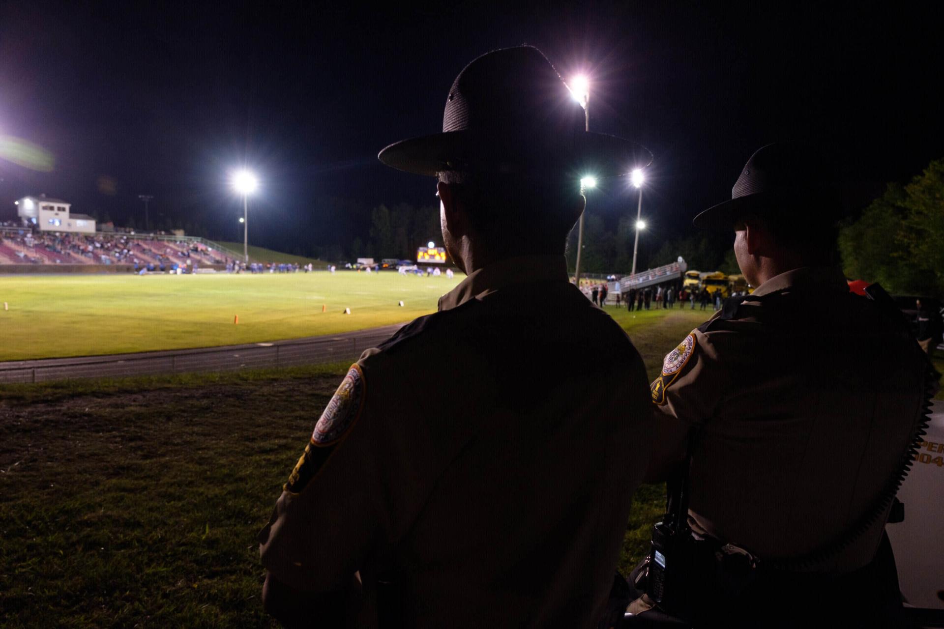 Sheriff Deputies watching football game at night