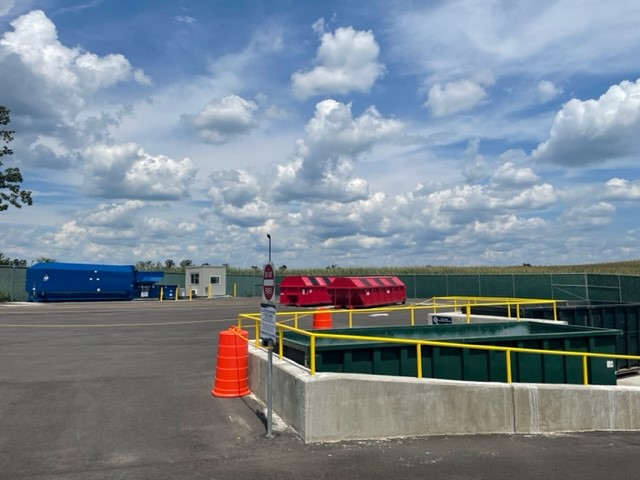 Photo of new Climax Convenience Center - compactor and several open top boxes and cloudy skies.